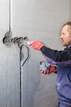 The electrician will plaster holes and channels for sockets and wires. Repair of apartments. Close-up