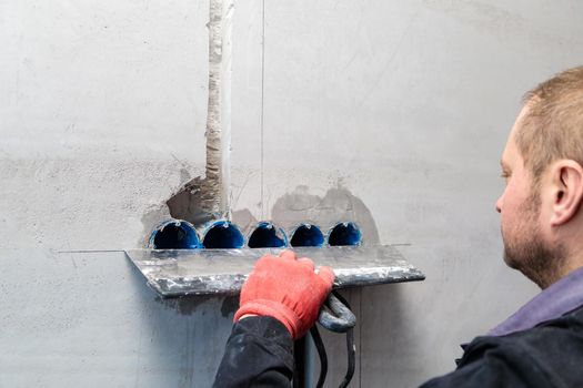 The electrician will plaster holes and channels for sockets and wires. Repair of apartments. Close-up