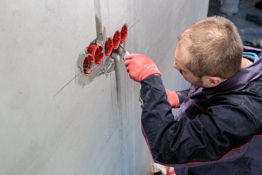 The electrician will plaster holes and channels for sockets and wires. Repair of apartments. Close-up