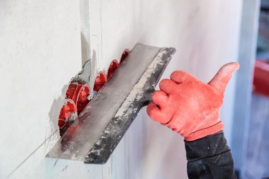 The electrician will plaster holes and channels for sockets and wires. Repair of apartments. Close-up