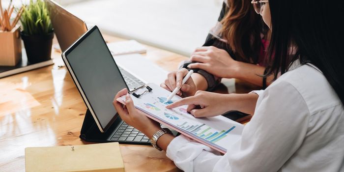 Two businesswomen discussing for financial chart report in office