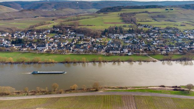 Aerial view of the river Moselle valley with cargo ship and the village Brauneberg 