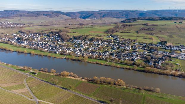 Aerial view of the river Moselle valley with the village Brauneberg and mountains in the background