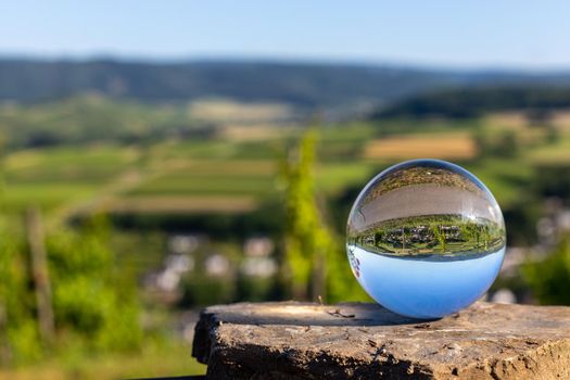 Crystal ball on shale stone with defocused river Moselle valley  in background