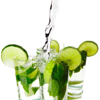 Making mojito cocktails with lime and mint isolated on white background