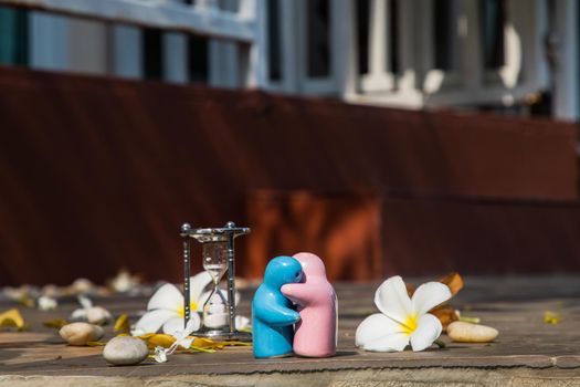 Blue and pink ceramic couple dolls hug with each other on stone background. Concept for anniversary, Wedding and eternal love concept, Romance wedding or Valentine’s day.
