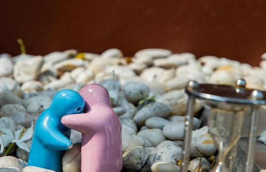 Blue and pink ceramic couple dolls hug with each other on stone background. Concept for anniversary, Wedding and eternal love concept, Romance wedding or Valentine’s day.
