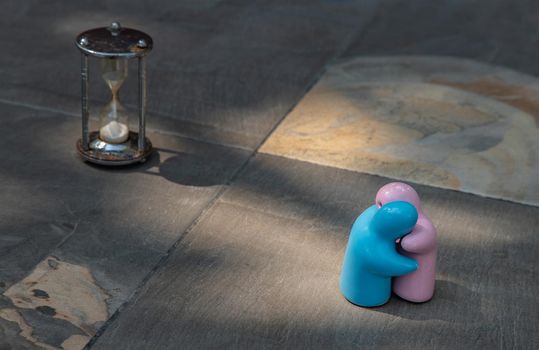 Blue and pink ceramic couple dolls hug with each other on stone background. Concept for anniversary, Wedding and eternal love concept, Romance wedding or Valentine’s day.