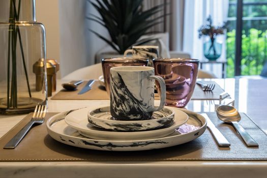 Dining table with vase of flower on marble table in home dining room. Interior design concept.