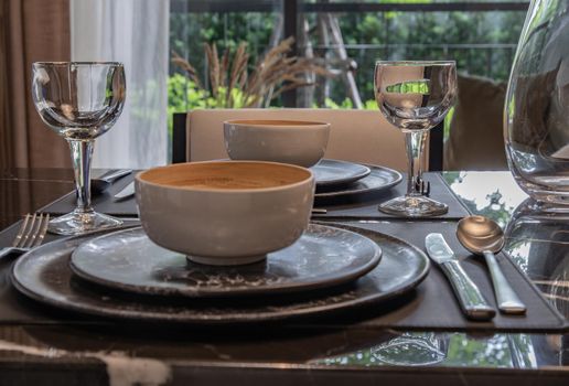 Dining table with vase of flower on marble table in home dining room. Interior design concept.