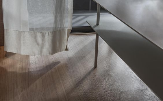 Rays of sunlight through curtain of open porch door of livingroom with The wind blew the curtain swaying along the wind.