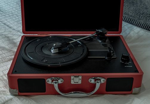 Portable turntable on white bed. Focus and blur.