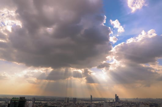 The sun's rays passing through the clouds and shining on shining on sky over view of bangkok city creates energetic feeling to get ready for the day waiting ahead. Copy space, Selective focus.