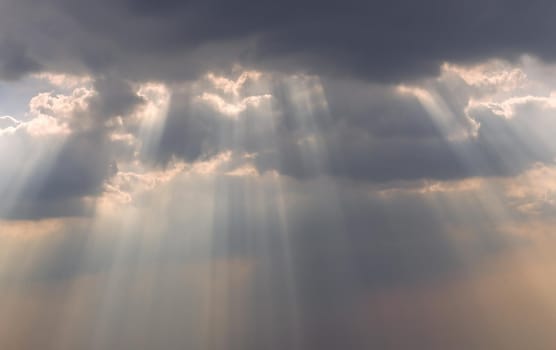 The sun's rays passing through the clouds and shining form an interesting light pattern against the sky. Copy space. Selective focus.