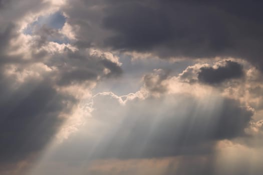 The sun's rays passing through the clouds and shining form an interesting light pattern against the sky. Copy space. Selective focus.