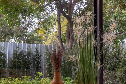 Backyard views and blooming flowers in summer time. House design for green living concept. Environmental friendly home design. No focus, specifically.