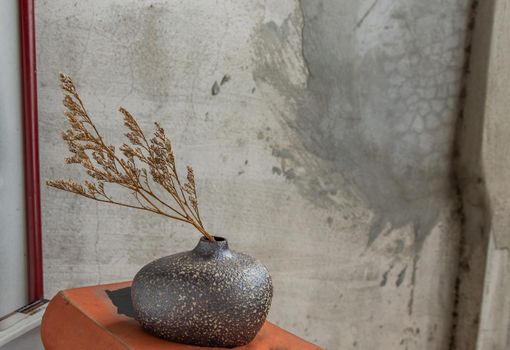 Dried flowers in Handmade Ceramic Vases and books on table. Home decor, Space for text.