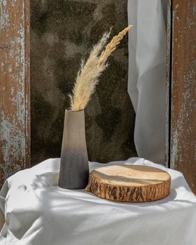 Dried flowers in Handmade Ceramic Vases and Wooden Board on Table. Home decor, Space for text.