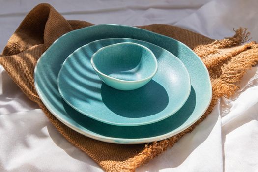 Set of Ceramic Plates with sackcloth decorative textile on white background. Ceramic tableware, Beautiful arrangement.