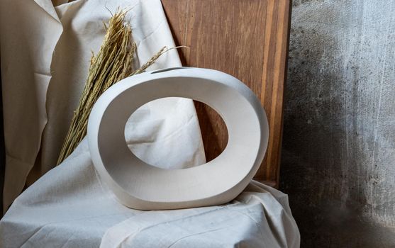 Beautiful ceramic white vase handmade on wooden chair. Home decor, Space for text.
