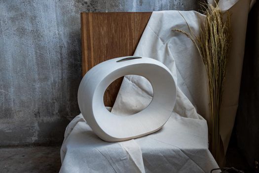 Beautiful ceramic white vase handmade on wooden chair. Home decor, Space for text.