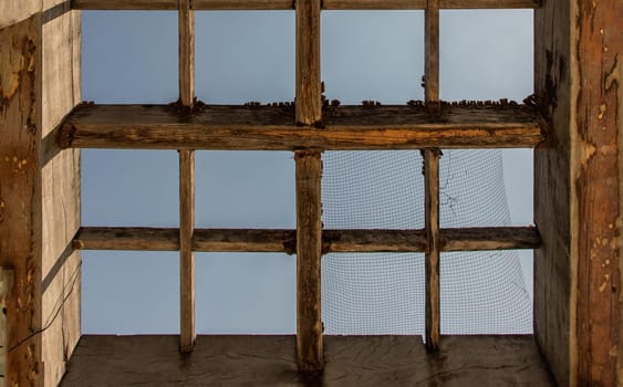 The old wooden battens roof structure of the outdoor vegetable garden. Selective focus.