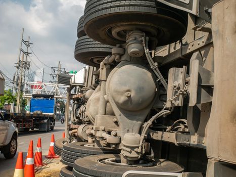 Close-up of A view of under the truck carrying a container overturned on a road under a bridge over an intersection.