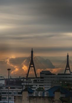 View of Bhumibol suspension bridge cross over Chao Phraya River in Bangkok city at beautiful sunset sky and clouds in Bangkok Thailand. Focus and blur.