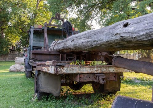 Old Logging truck with wooden logs on old traditional farm area. Abandoned car, Selective focus.