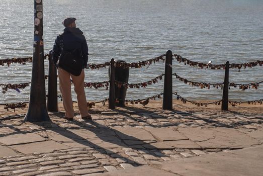 Liverpool, United Kingdom - 03 Jan 2019 : The back of Lonely young man standing on the river walk and looking at skyline. No focus, specifically.