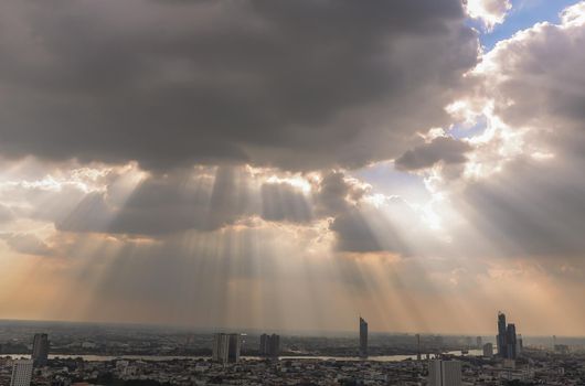 Bangkok, Thailand - Nov 03, 2020 : The sun's rays passing through the clouds and shining on shining on sky over view of bangkok city creates energetic feeling to get ready for the day waiting ahead. Copy space, Selective focus.