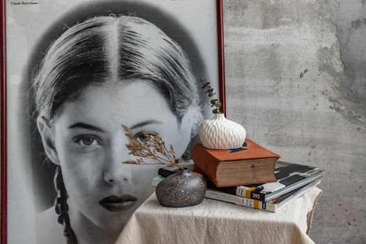 Dried flowers in Handmade Double ceramic Vases and books on table. Home decor, Space for text.