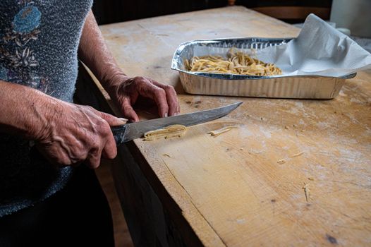 the grandmother prepares homemade egg pasta noodles