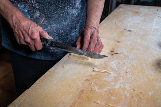the grandmother prepares homemade egg pasta noodles