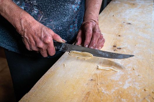 the grandmother prepares homemade egg pasta noodles