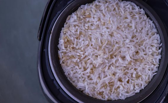 Jasmine rice Cooking mixed with Coarse brown rice (milled rice imperfectly cleaned, unpolished or half milled rice) in electric rice cooker with steam. Healthy food and diet concept. Copy space, Selective focus.