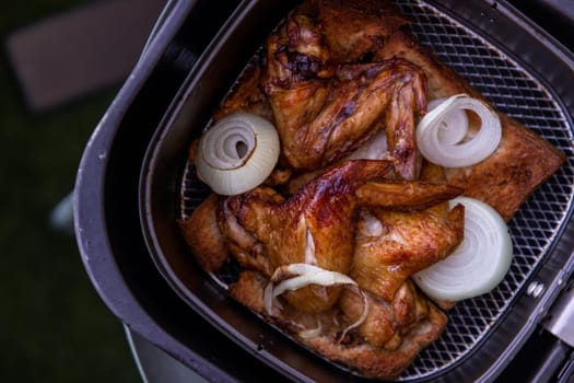 Baked pickled chicken wings and Onion. Cooking chicken with spices puts on slice of bread in the Hot air oven. Selective focus.