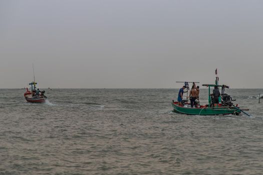 Phetchaburi,Thailand - Mar 15, 2020 : The fishermans and wooden fishing boats used as a vehicle for finding fish in the sea. Selective focus.