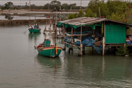 Phetchaburi,Thailand - Mar 15, 2020 : The fisherman and wooden fishing boat used as a vehicle for finding fish in the sea. Selective focus.