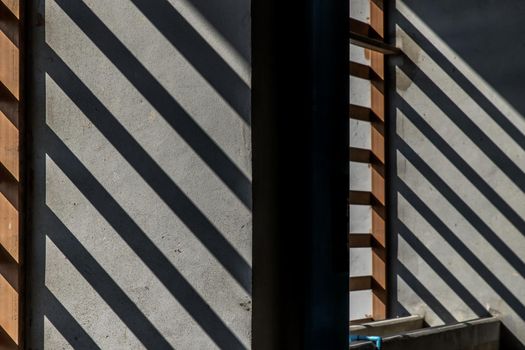 Bright rays of morning light shine through the wall, shadows on the Cement wall on Parking garage.