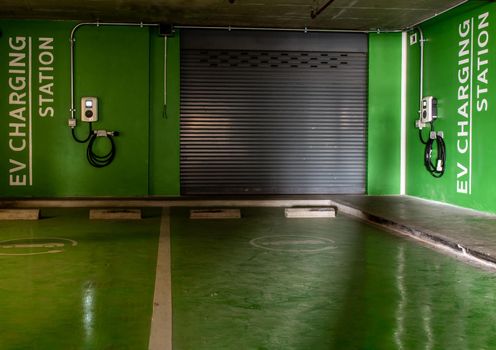 Bangkok, Thailand - Jan 04, 2020 : Front view of electric vehicle charging station and battery on the wall in a building parking lot, Fast battery exchange solution.