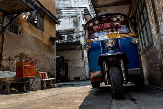 Bangkok, Thailand - Jan 19, 2020 : Famous blue Tuk Tuk, The front of thai traditional taxi parked near the old house.