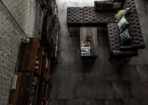 Bangkok, Thailand - 15 Dec 2019 : Minimalist modern living room with leather sofa and brick wall in loft style, Top view.