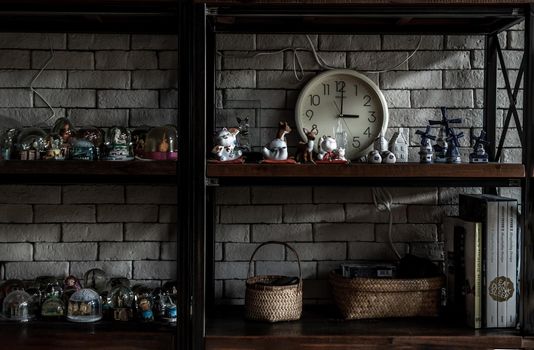 Bangkok, Thailand - 15 Dec 2019 : Souvenir and collectible objects from different cities of the world on books shelf in loft style home.