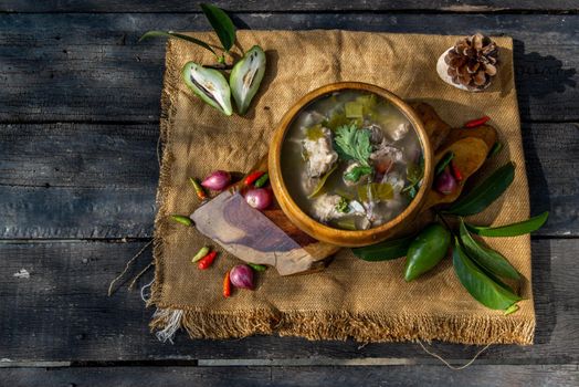 Pork spare rip Madan soup (Kra Dook Moo Tom Ma-Dun) in a Wooden bowl, Traditional Thai food, Top view.