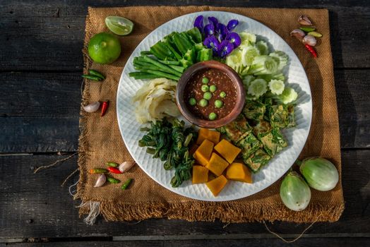 Thai Traditional Local Food : Spicy Shrimp Paste Dip or Fried shrimp paste sauce (Nam Prik Kapi) with blanched vegetables and cha-om omelets.