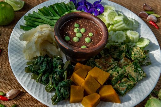 Thai Traditional Local Food : Spicy Shrimp Paste Dip or Fried shrimp paste sauce (Nam Prik Kapi) with blanched vegetables and cha-om omelets.