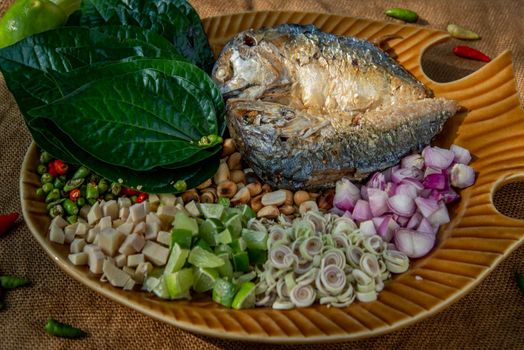 Thai Traditional Food : Fried mackerel served with fresh vegetable and herb, This food is thai food call Meuang Mackerel (Maing-Pla-too) menu.