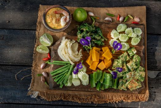 Thai Traditional Local Food : Shrimps chili dip or nam prik with shrimps (Nam Prik Goong Sod) with blanched vegetables and cha-om omelets on wooden backgroud.