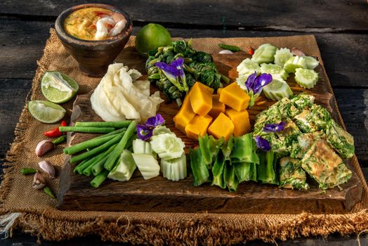 Thai Traditional Local Food : Shrimps chili dip or nam prik with shrimps (Nam Prik Goong Sod) with blanched vegetables and cha-om omelets on wooden backgroud.